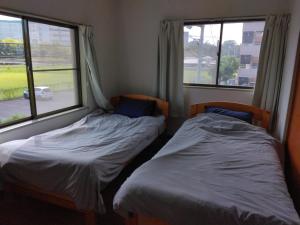 two beds in a room with two windows at Townhouse No, 3 - Vacation STAY 43084v in Sanuki