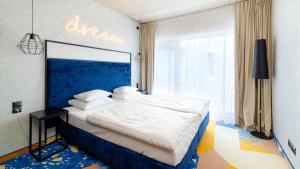 a bedroom with a large bed with a blue headboard at Czarna Góra Biała Perła EnergyApart in Sienna