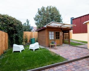 a small shed with two white chairs in a yard at An der Linde in Sargstedt