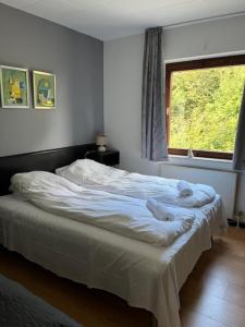 a bedroom with a bed with white sheets and a window at Egtved Hotel in Egtved