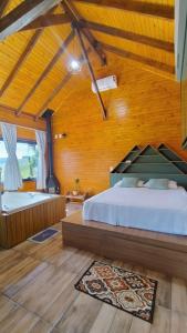 Un dormitorio con una cama y una bañera en una habitación. en Chico Cabanas, en Lajeado Grande