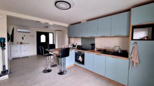 a kitchen with blue cabinets and a table in it at Opporak in Boucau