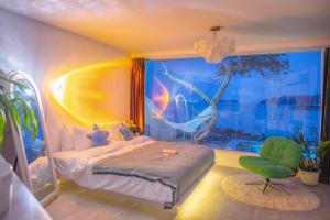 a bedroom with a bed and a chair and a window at White Beachfront Pool Villa Koh Larn in Ko Larn