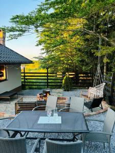 a patio with a table and chairs and a swing at Casa Hardic in Horodnic de Sus
