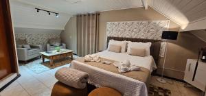 a bedroom with a large bed with towels on it at Pousada Flor de Lua Monte Verde in Monte Verde