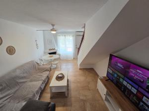 a living room with a couch and a flat screen tv at "Ancla-Blanca" Ocean View Duplex 2min Beach Cabo Roig - La Zenia in Orihuela Costa