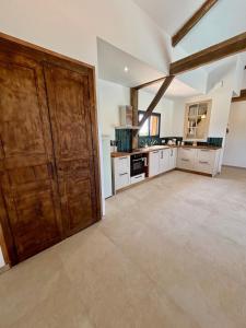 a large kitchen with wooden cabinets and a large door at Vignes du Roc in Rayet +13 photos