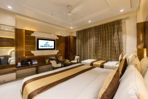 a hotel room with a bed and a television at Hotel Grand Plaza in City Centre - Walking Distance From New Delhi Railway Station and Connaught Place in New Delhi