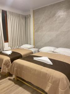a hotel room with two beds with towels on them at Hotel 888 in Oxapampa