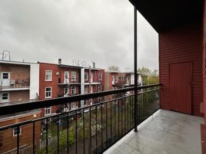 モントリオールにあるFULL KITCHEN 10min from DTOWN Room Bの赤いドア付きのバルコニーと一部の建物