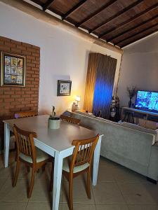 a living room with a table and chairs and a couch at Loft charmoso! in Água Boa