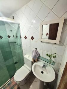 a bathroom with a toilet and a sink and a shower at Loft charmoso! in Água Boa