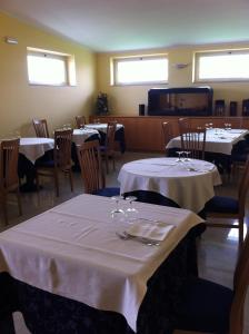 un comedor con mesas y sillas con mantel blanco en Hotel Atleti en Foggia