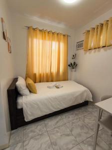 a small room with a bed with a window at AMS Apartment in Butuan +10 photos