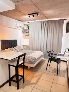 ein Zimmer mit einem Bett und einem Tisch und Stühlen in der Unterkunft Montevideo Suites con Balcón in Rosario