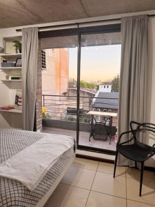 ein Schlafzimmer mit Bett und Blick auf einen Balkon in der Unterkunft Montevideo Suites con Balcón in Rosario + 15 Fotos