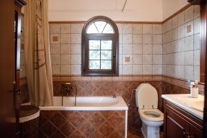 Un baño con bañera, inodoro y ventana. en Olympus Leptokaria’s Luxurious Villa, en Leptokarya 44 fotos más