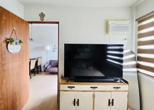 TaytayにあるThe Hive Cozy 1-BR Retreatの大型薄型テレビのあるリビングルーム +4枚の写真