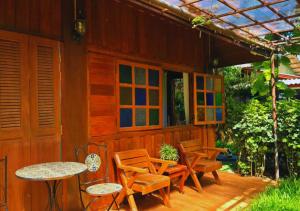 a patio with chairs and tables and a building at Him Jan Home in Ban Kio Phrao
