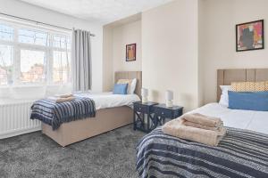 a bedroom with two beds and a window at Ormesby House in Hartlepool