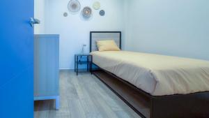 a bedroom with a bed with a night stand and a blue wall at ZIELO Modern apt steps to Zocalo Rooftop view in Mexico City +87 photos