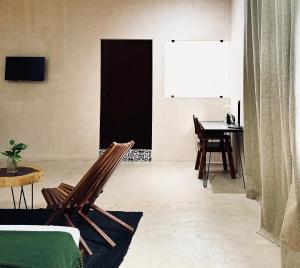 una sala de estar con una mesa y una silla en Hotel Casa Nudo, Ukax, Mérida, en Mérida 22 fotos más