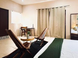 Un dormitorio con dos sillas y una mesa y una cama. en Hotel Casa Nudo, Ukax, Mérida, en Mérida