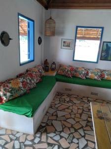 a room with a couch and a table and windows at Quarto duplo de frente para o mar, Casa da Jô in Angra dos Reis +15 photos