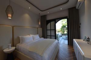 a bedroom with a large bed and a bathroom at ridgevillabali in Kerobokan