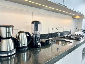 a kitchen counter with a blender and a sink at Apartamento Inteiro - 2 Quartos com AC - Wifi 1000mb - Piscina - 1 Vaga de Garagem - Elevador - Sacada Gourmet - Indicado para Grupos, Hospedes a Trabalho, Família e Pets in Toledo