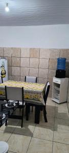 アパレシーダにあるCasa de temporada em Aparecidaのテーブルと椅子が備わる客室です。