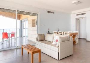 a living room with a couch and a table at O&O Group - Stunning Sea View 3 BR Apartment Iconic Tower in Bat Yam
