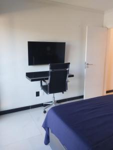 une chambre avec un lit, un bureau et une télévision dans l'établissement Eco paradise 226, à Cumbuco
