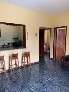 a room with two chairs and a counter and a kitchen at Apartamento Beira Mar Ilha de Mosqueiro in Belém