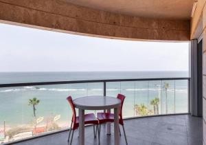 a table and chairs on a balcony with a view of the beach at O&O Group - Stunning Sea View 3 BR Apartment Iconic Tower in Bat Yam