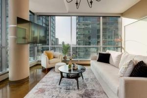a living room with a white couch and a table at 2Bed DT-Mountain & Skyline Views- Colours 1st-BMO in Calgary