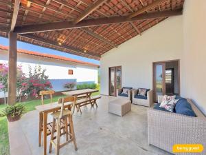 a patio with a wooden pergola and a table and chairs at Reserva BeachFront - Retirinho in Aracati