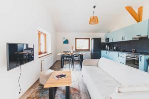 a living room with a white couch and a table at DOMEK Písařov - apartmány in Písařov