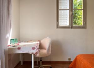 a white table with a chair and a window at Agréables Chambres Centre-Ville Aix in Aix-en-Provence