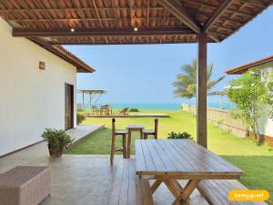 a patio with a table and a view of the ocean at Reserva BeachFront - Retirinho in Aracati