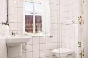 a white bathroom with a sink and a toilet at Lotshotellet in Käringön