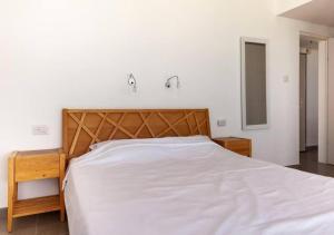 a bedroom with a large bed with a wooden headboard at O&O Group - Stunning Sea View 3 BR Apartment Iconic Tower in Bat Yam