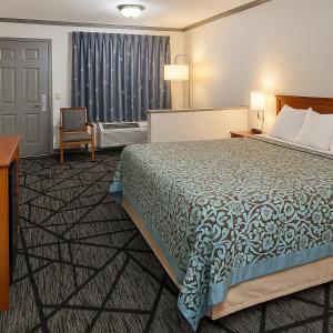 マニングにあるBest Inn Manningのベッドと椅子のあるホテルの部屋