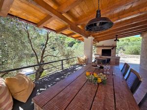 a wooden table with a bowl of fruit on a deck at Villa Brač in Sumartin