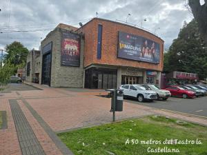 a building with cars parked in a parking lot at Hotel Castellana 95 Bogota By Hoteles Confort 80 in Bogotá