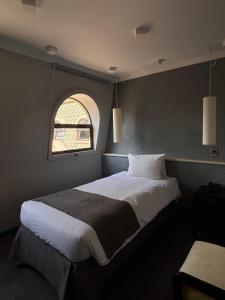 a bedroom with a large bed with a window at Hotel Fundador in Santiago