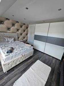 a bedroom with a large bed with a leather headboard at Luxus Apartman in Szombathely