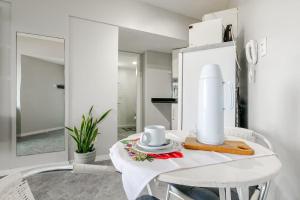 Una cocina blanca con una mesa con dos tazas. en Lindo vista mar na Praia do Buracão - Rio Vermelho, en Salvador