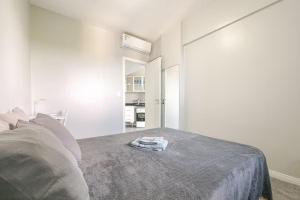 Una habitación blanca con una cama con una manta gris. en Lindo vista mar na Praia do Buracão - Rio Vermelho, en Salvador 39 fotos más