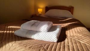 a bed with two white towels on top of it at Biały Domek Nielbark - Agroturystyka in Nielbark